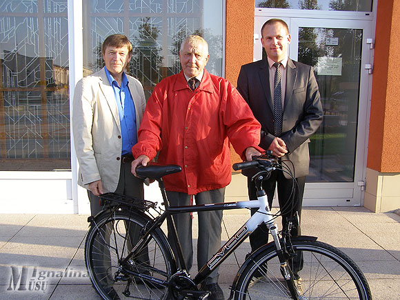 Algirdas Sekonas su naujuoju dviračiu. Kairėje – rajono vicemeras Henrikas Šiaudinis, dešinėje – Artūras Česliokas.