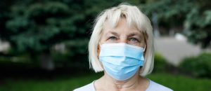 COVID-19 Coronavirus woman wearing medical mask in city park during pandemic