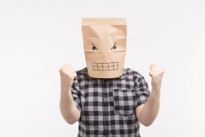 Angry man in paper bag mask punching