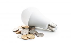 Energy saving light bulb. LED light bulb and dollar coins.